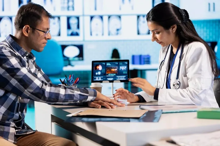 Doctor explaining test results on a laptop to a patient